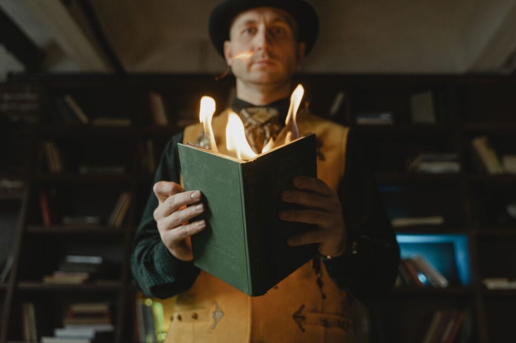 Un magicien tient un livre en flammes lors d'un tour de magie dans une pièce intérieure